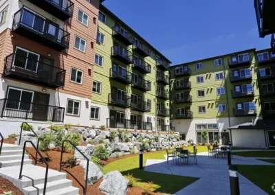 Apartment courtyard with bark beds, rockery planting and outdoor seating