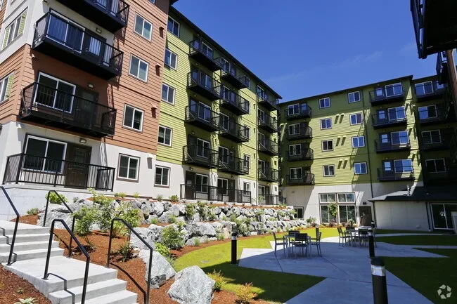 Apartment courtyard with bark beds, rockery planting and outdoor seating