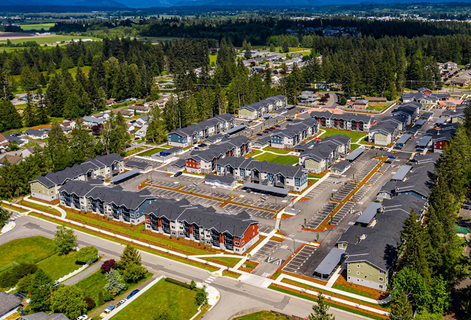 Aerial view of a multi-building residential community with landscaped common areas
